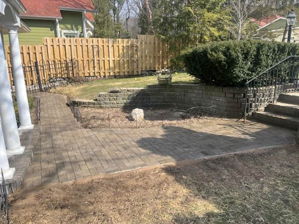 patio and retaining wall with privacy fence in background